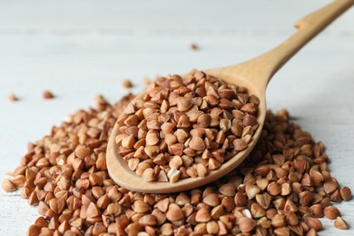 Buckwheat grains on white wooden table, closeup