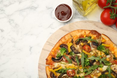 Photo of Delicious vegetarian pizza served on white marble table, top view. Space for text