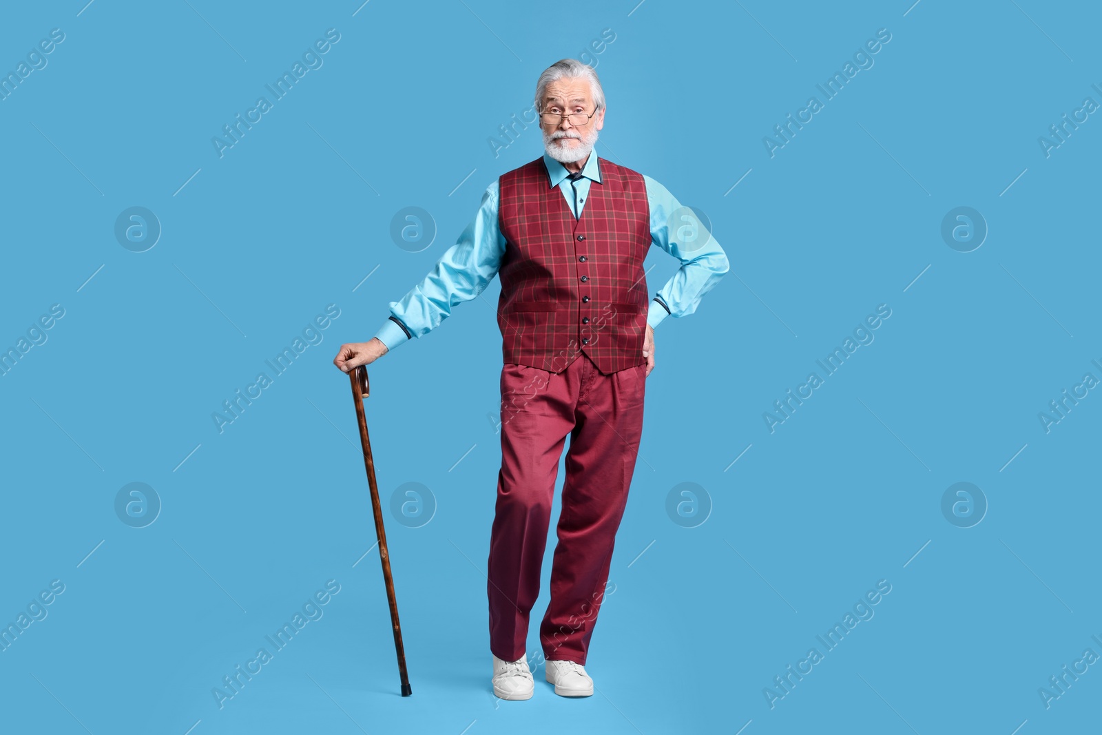 Photo of Senior man with walking cane on light blue background