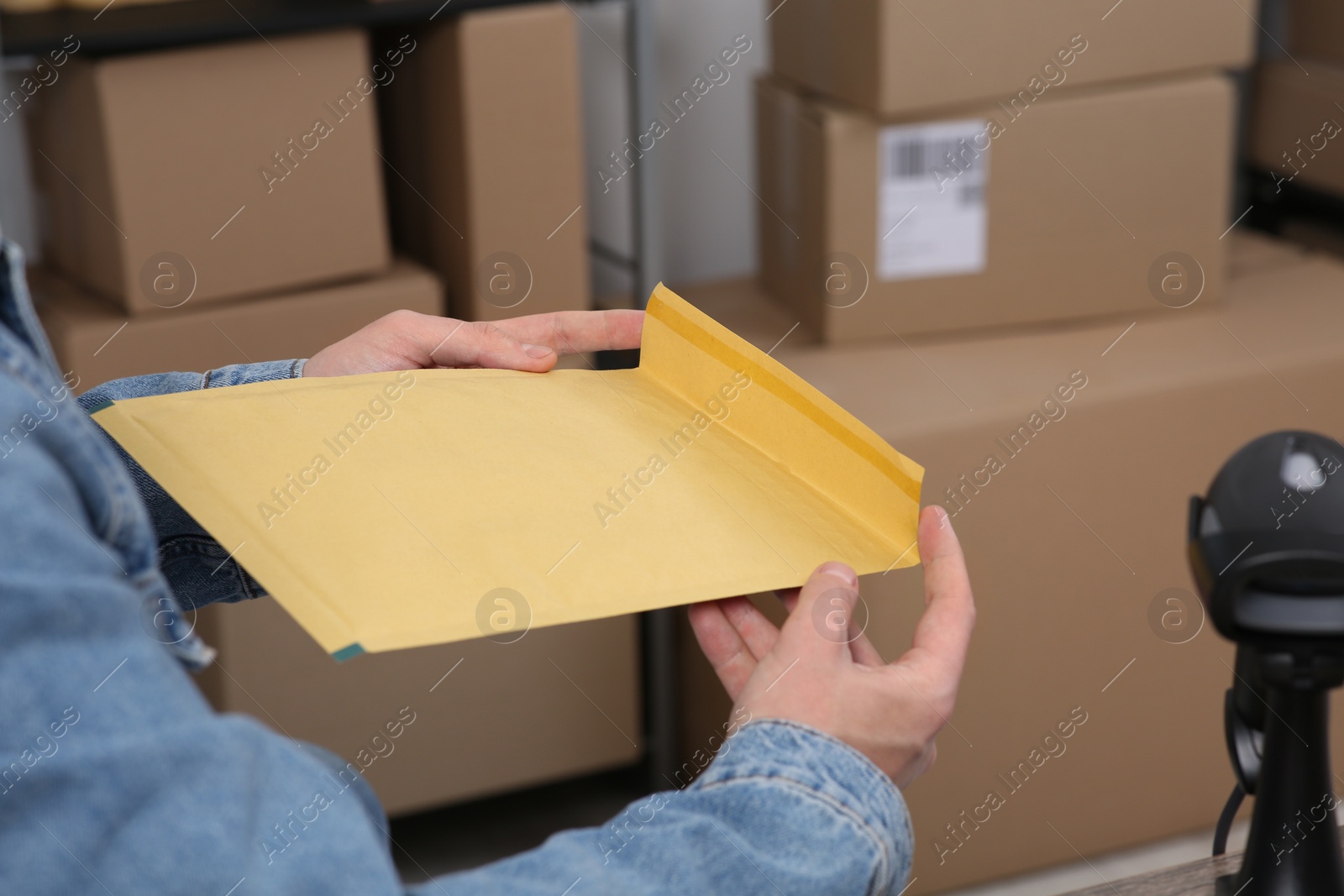 Photo of Seller packing parcel in office, closeup. Online store