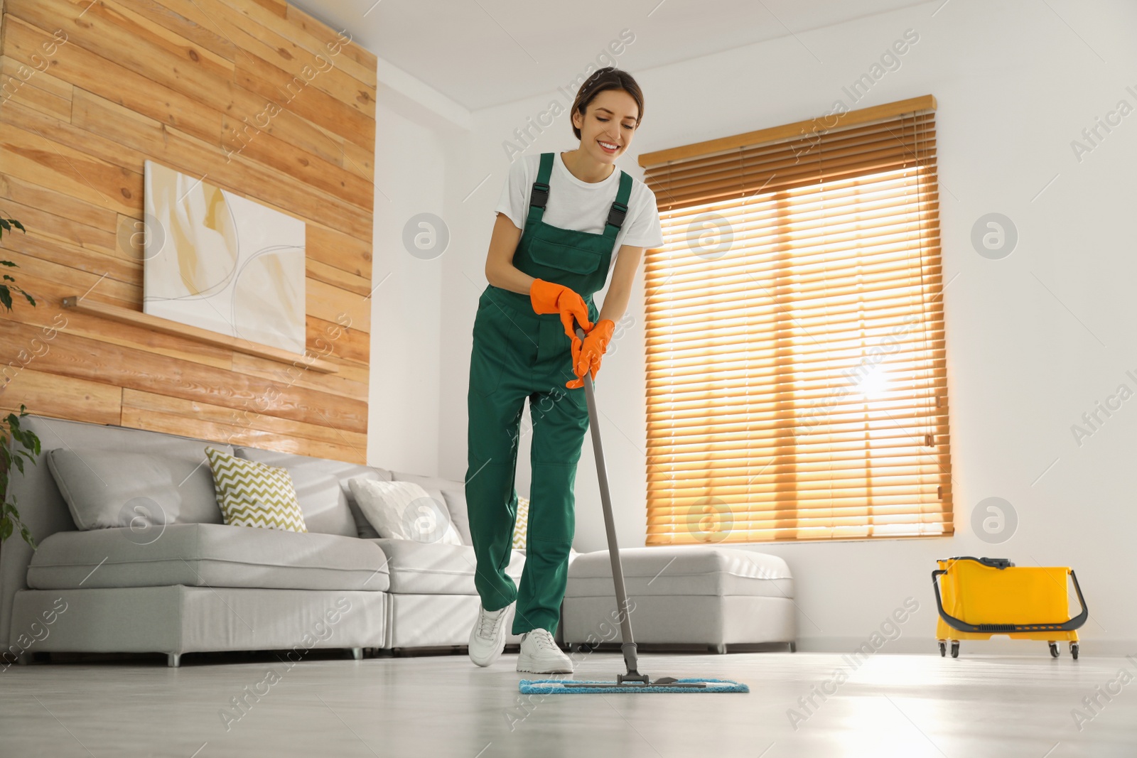 Photo of Woman cleaning floor with mop at home