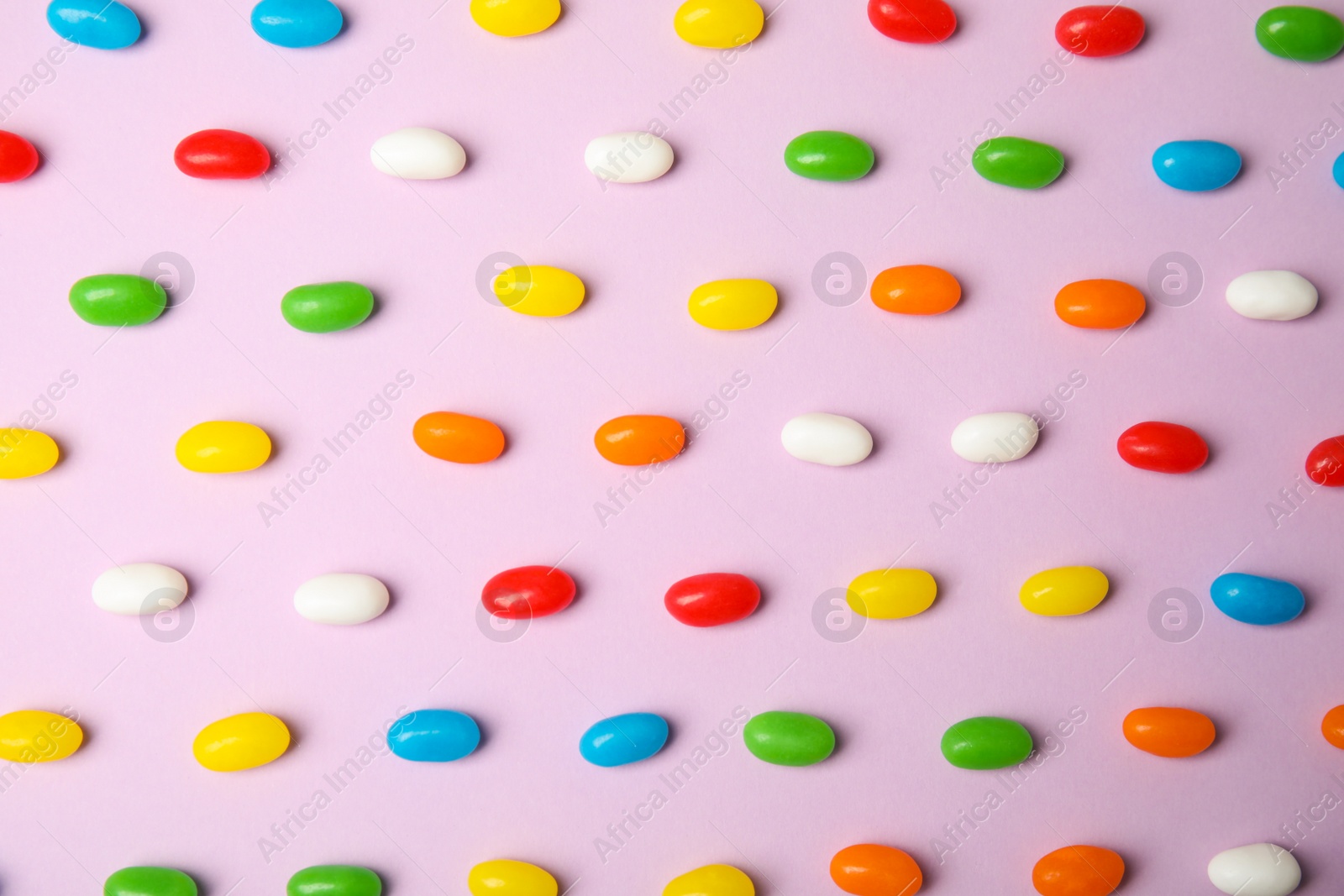 Photo of Flat lay composition with jelly beans on color background