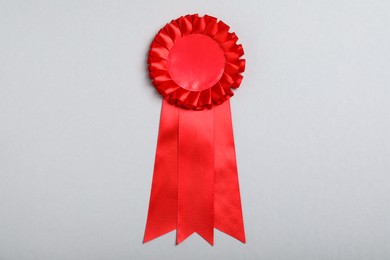 Photo of Red award ribbon on grey background, top view