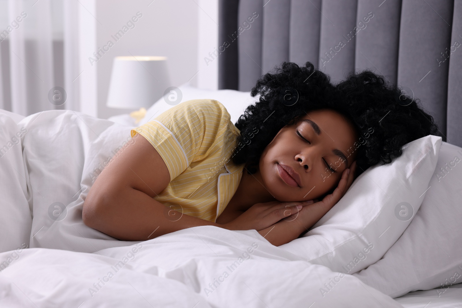 Photo of Beautiful young woman sleeping in soft bed at home