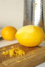 Photo of Lemon zest and fresh fruit on wooden board, closeup