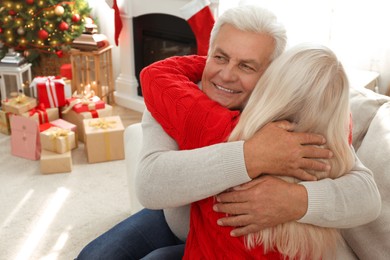 Photo of Happy mature couple hugging at home. Christmas celebration