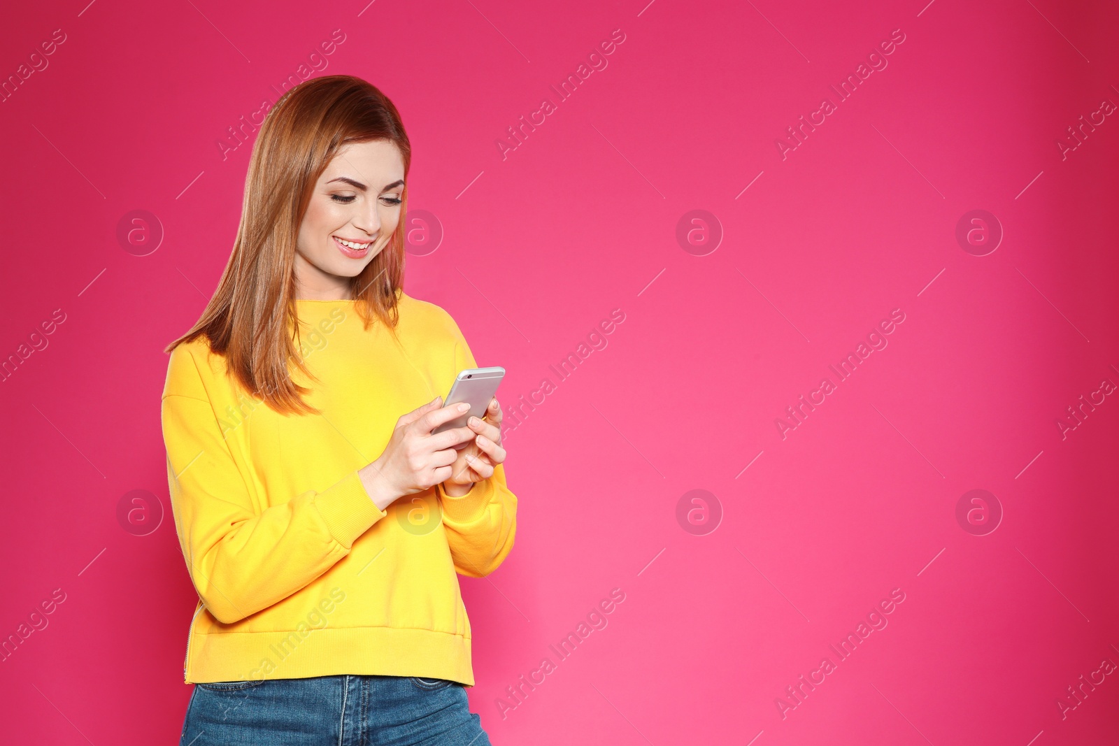 Photo of Portrait of beautiful woman with mobile phone against color background. Space for text