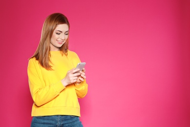 Portrait of beautiful woman with mobile phone against color background. Space for text