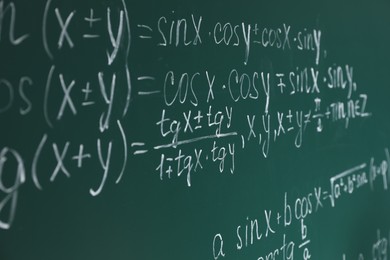 Many different math formulas written on chalkboard