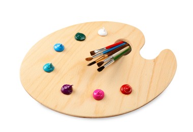 Photo of Wooden artist's palette with brushes and samples of paints isolated on white