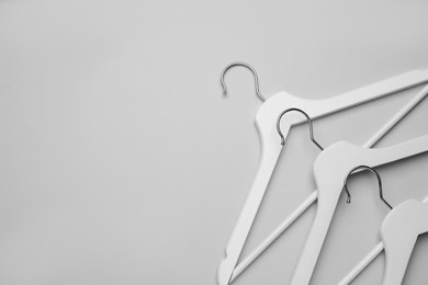 Empty clothes hangers on white background, flat lay. Space for text