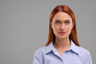 Portrait of beautiful young woman on grey background, space for text