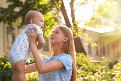 Photo of Teen nanny with cute baby outdoors on sunny day