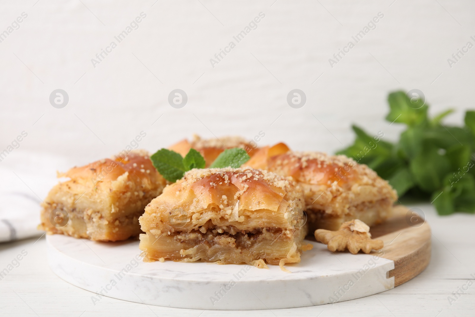 Photo of Eastern sweets. Pieces of tasty baklava on white wooden table, closeup