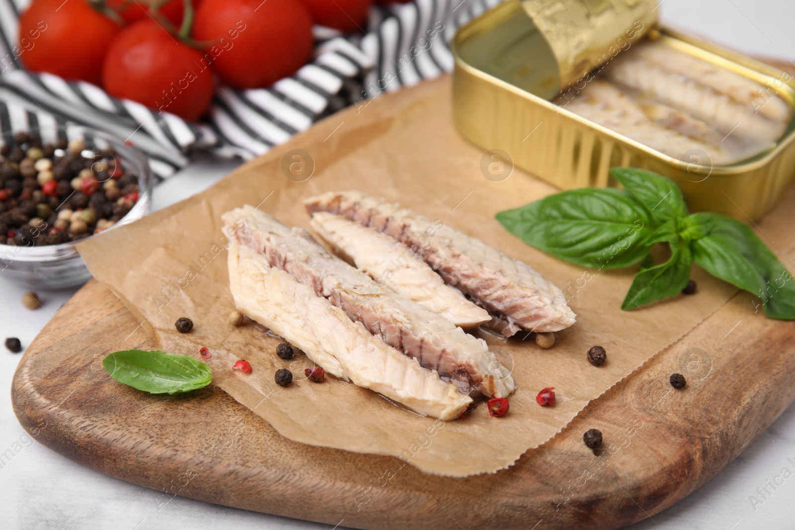 Photo of Canned mackerel fillets served on grey table, closeup