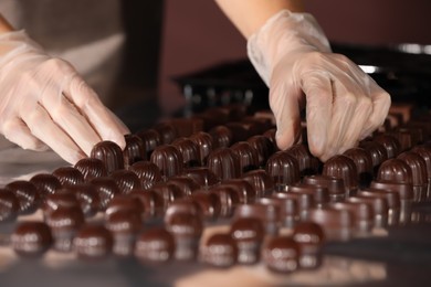 Woman with delicious candies at production line, closeup