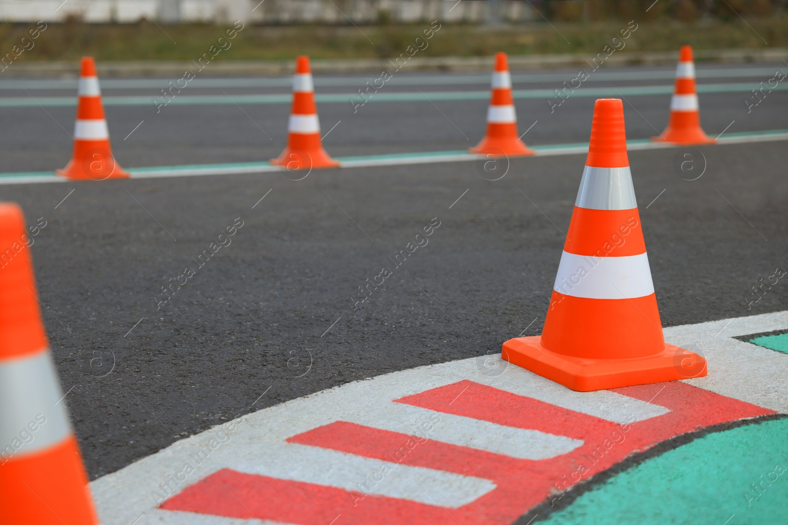 Photo of Driving school test track with marking lines, focus on traffic cone