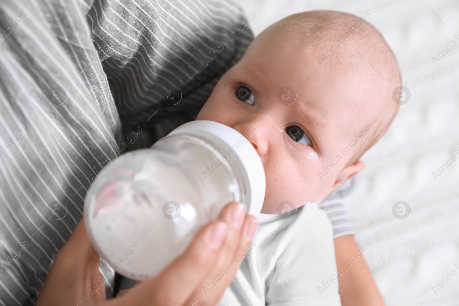 Photo of Mother feeding her little baby from bottle, closeup