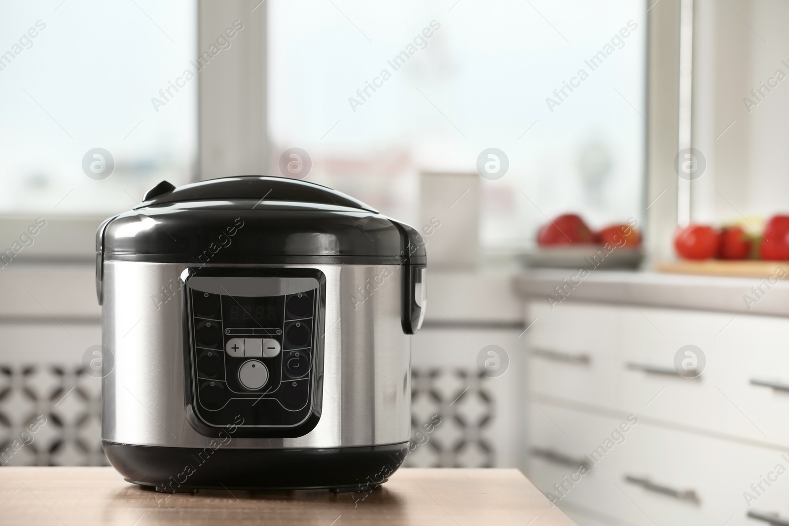 Photo of Modern multi cooker on table in kitchen. Space for text