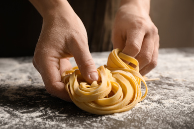 Photo of Woman holding pasta at table, closeup view