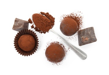 Photo of Delicious truffles, cocoa powder and chocolate on white background, top view