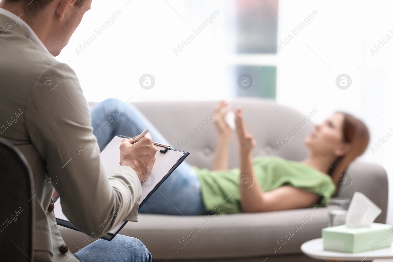 Photo of Psychotherapist working with woman in light office