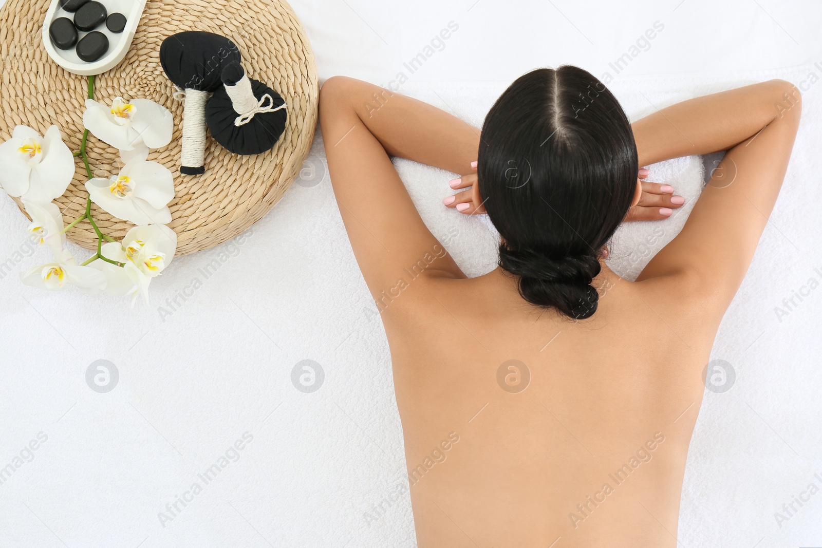 Photo of Young woman relaxing in spa salon, top view