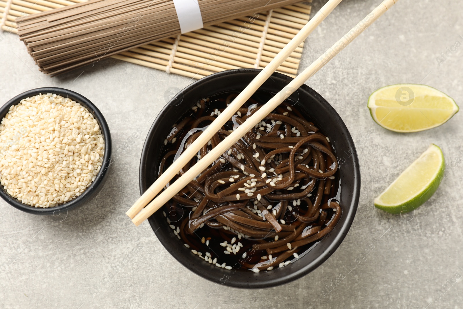 Photo of Tasty buckwheat noodles (soba) with sauce served on light table, flat lay