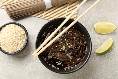 Photo of Tasty buckwheat noodles (soba) with sauce served on light table, flat lay