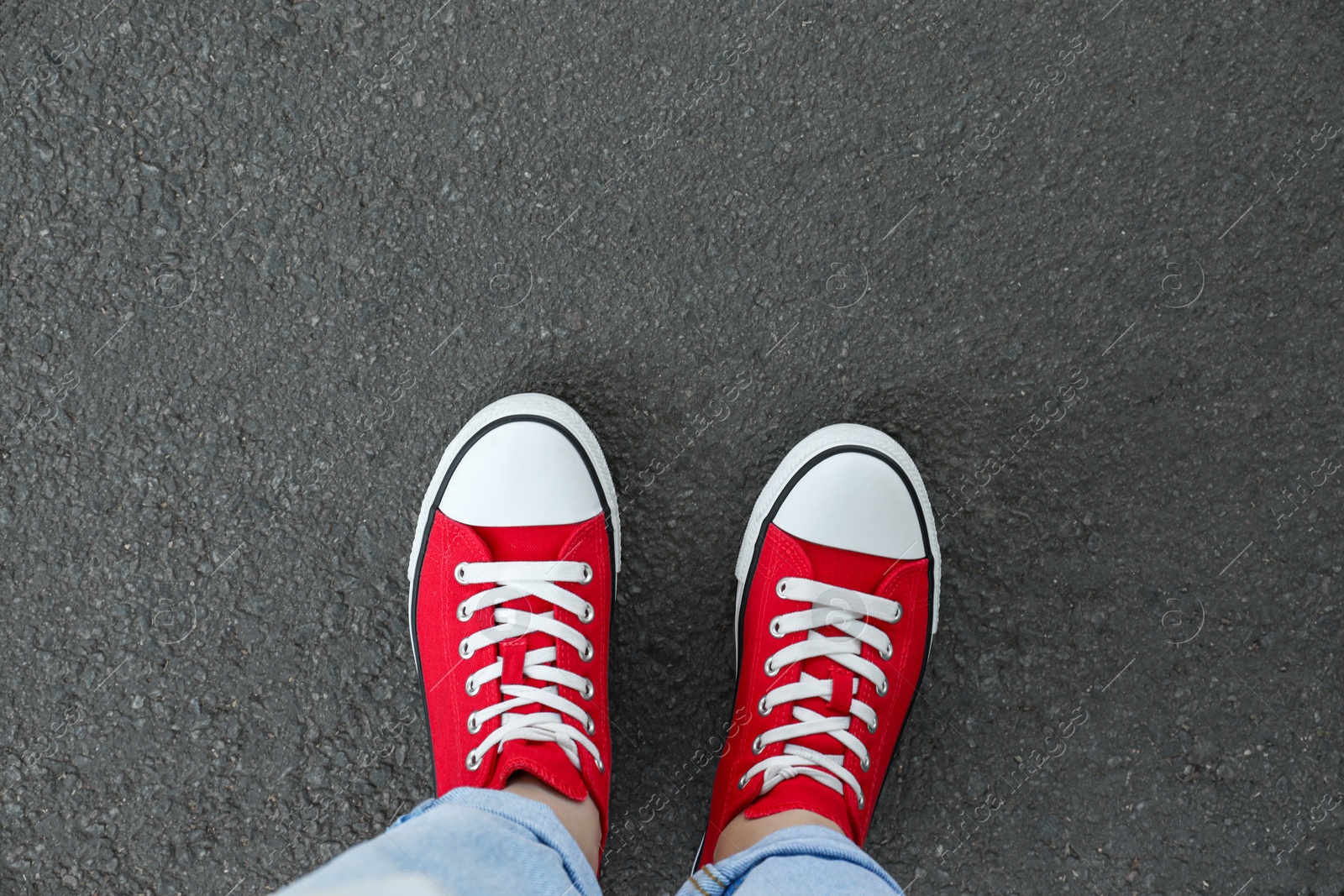 Photo of Woman standing on asphalt, top view. Space for text