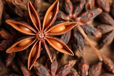 Photo of Fresh and dry aromatic anise stars on table, closeup