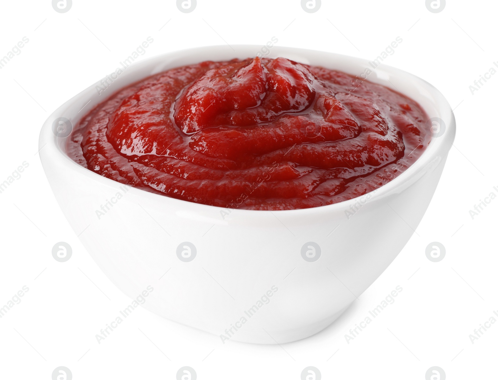 Photo of Tasty ketchup in bowl isolated on white, closeup