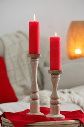 Beautiful burning candles on table in living room
