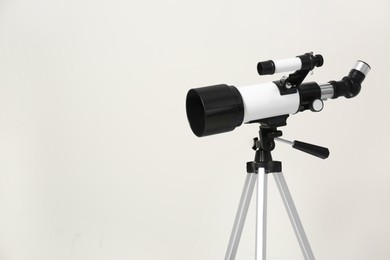 Photo of Tripod with modern telescope on white background, closeup. Space for text