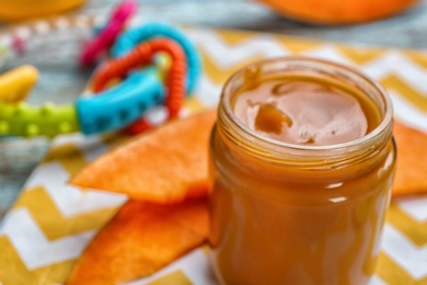 Photo of Jar with healthy baby food on table, closeup