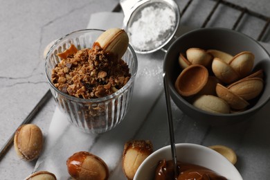 Delicious walnut shaped cookies with condensed milk on grey table, closeup