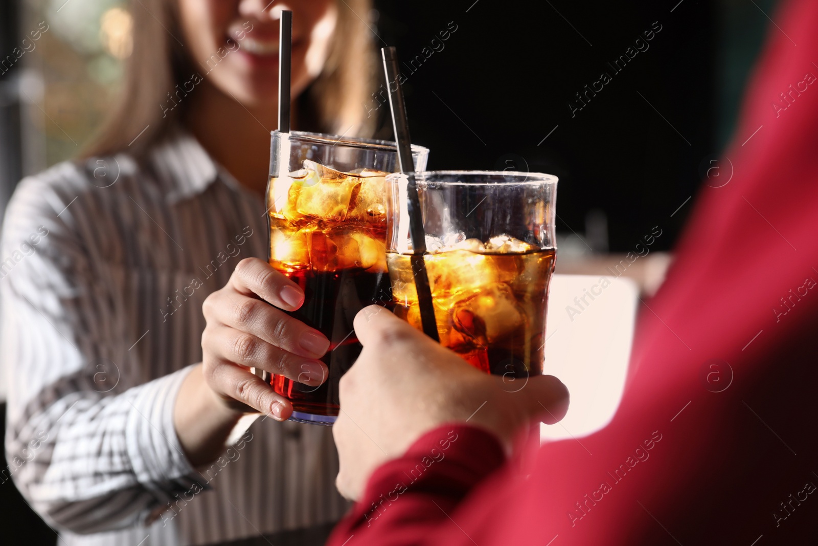 Photo of Young couple with glasses of refreshing cola indoors, closeup