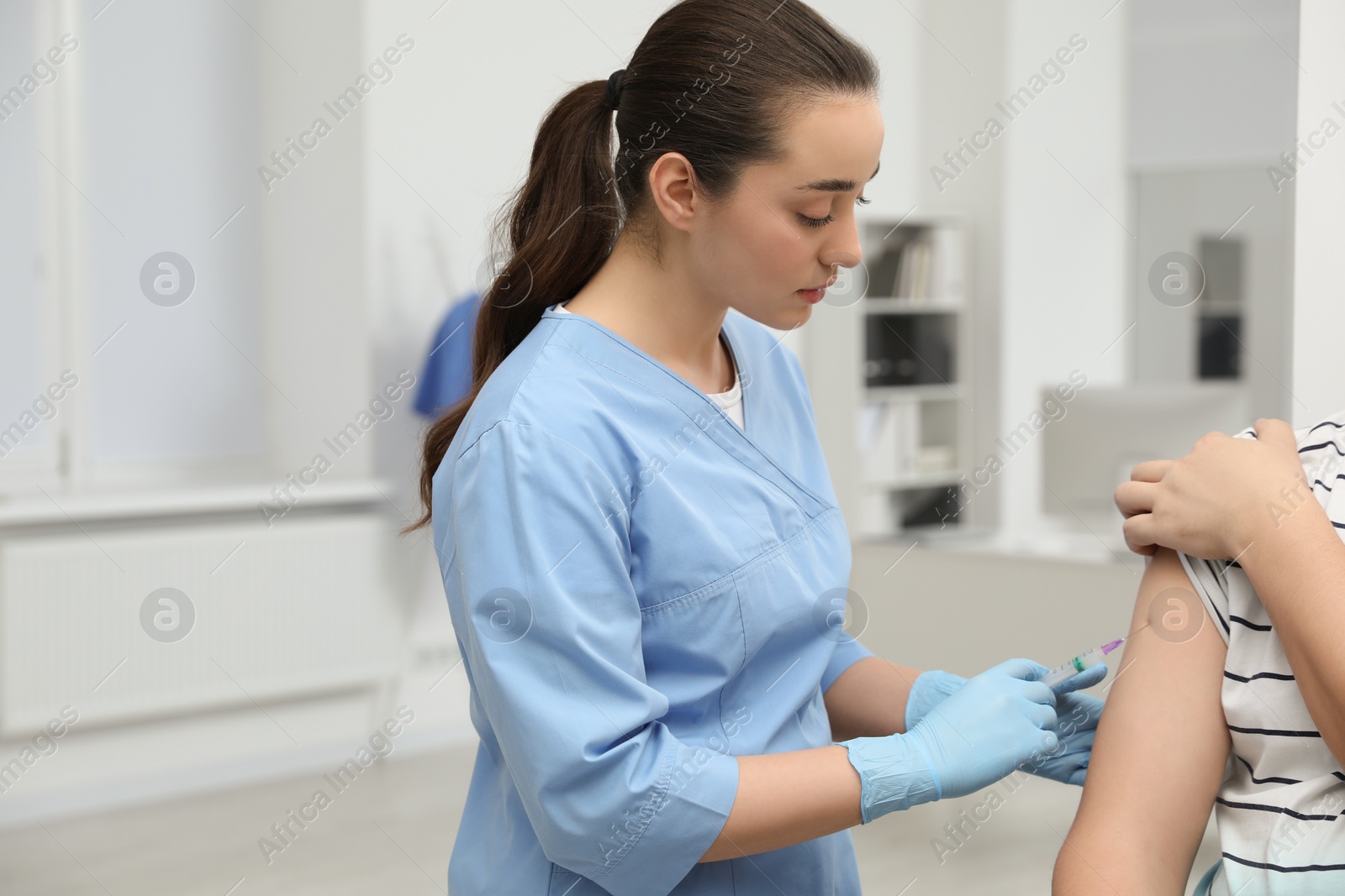 Photo of Doctor giving hepatitis vaccine to patient in clinic. Space for text