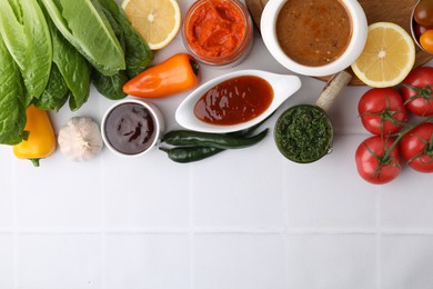 Photo of Different marinades and products on white tiled table, flat lay. Space for text