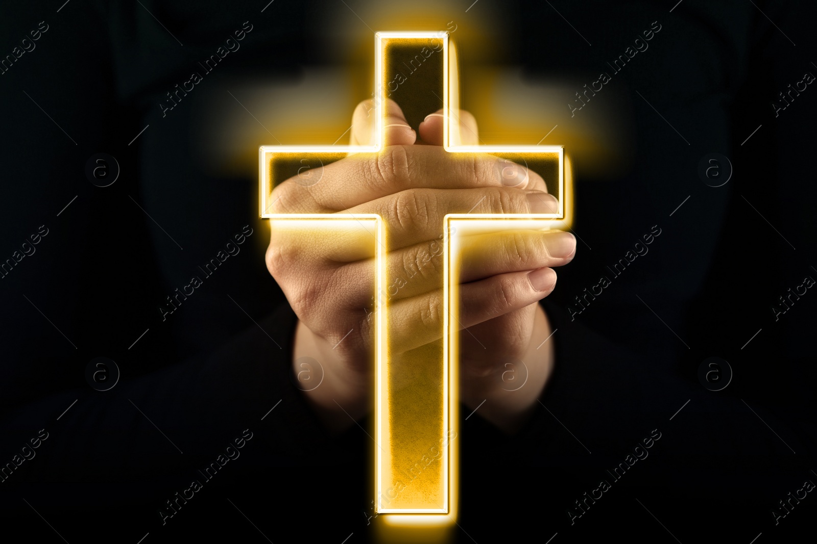 Image of Christian cross and woman holding hands clasped while praying in darkness, closeup