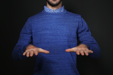 Man showing BLESS gesture in sign language on black background, closeup