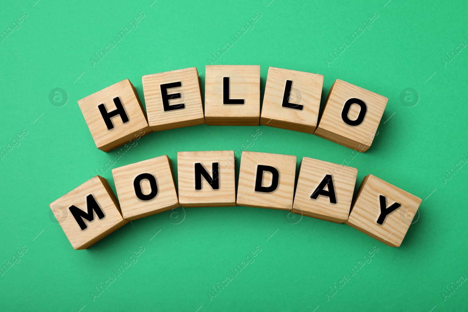 Photo of Wooden cubes with message Hello Monday on green background, flat lay