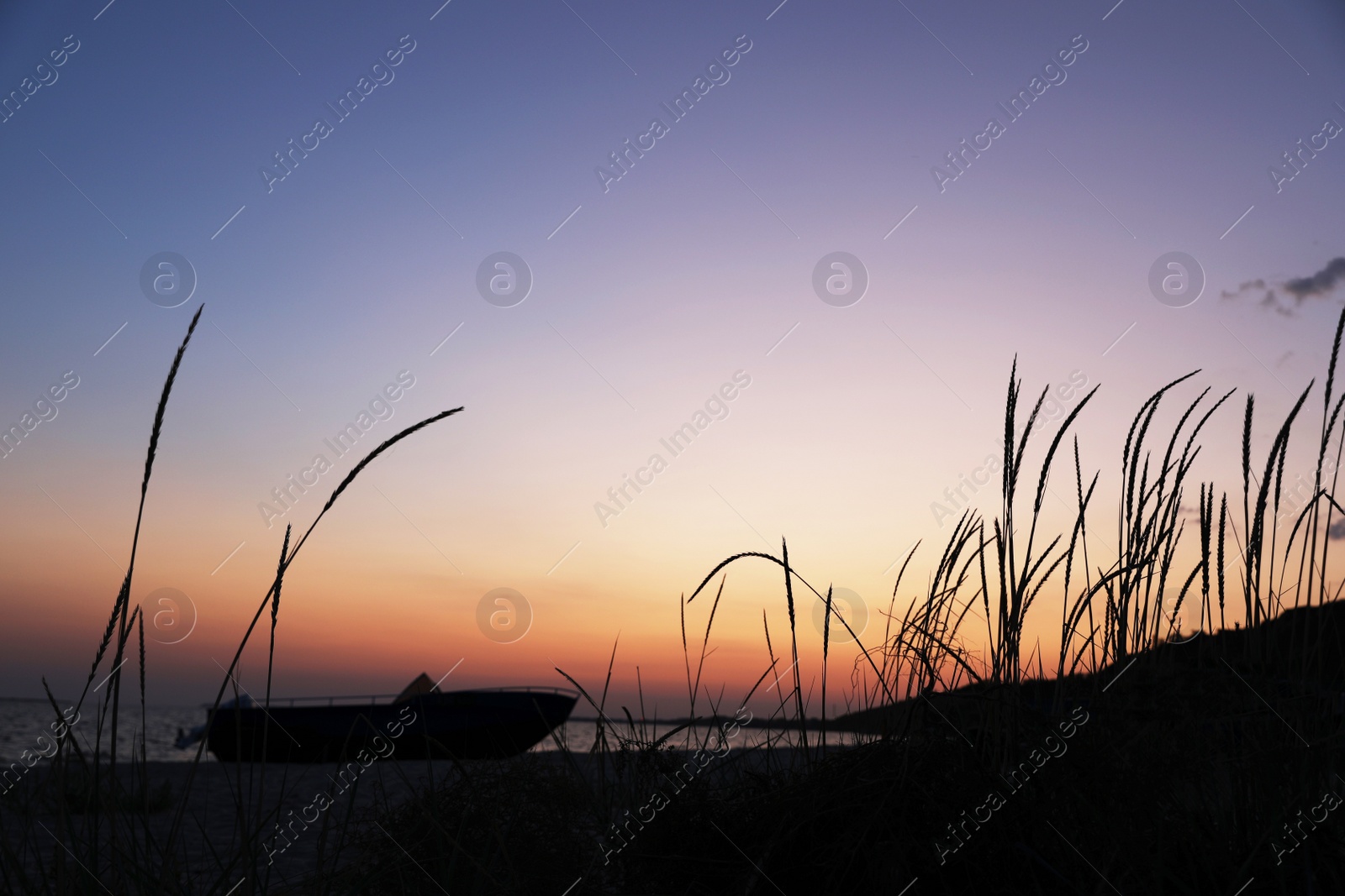 Photo of Beautiful view of beach with boat at sunset