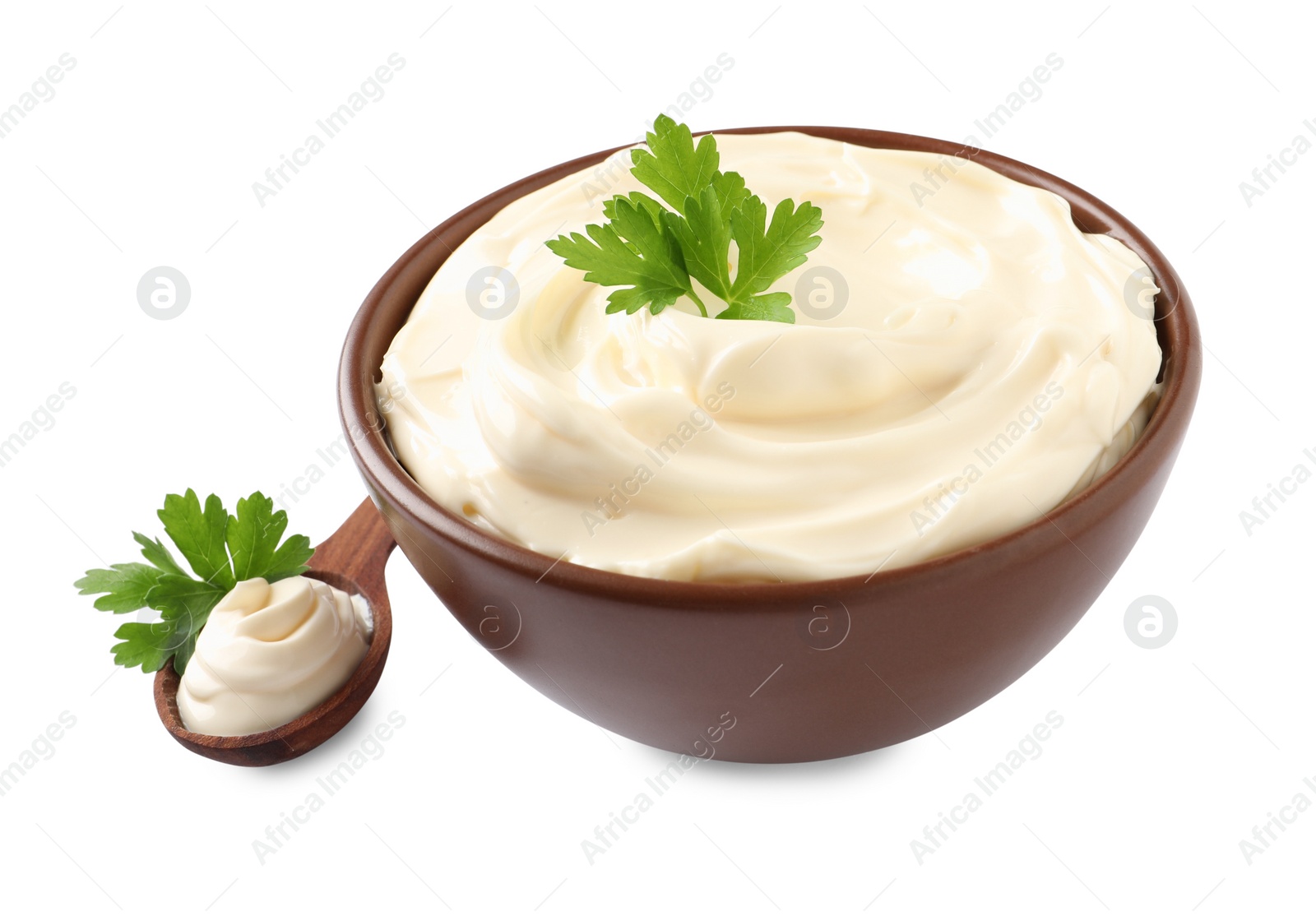 Photo of Spoon and bowl of delicious mayonnaise with parsley on white background