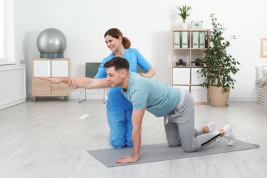 Photo of Physiotherapist working with patient in clinic. Rehabilitation therapy