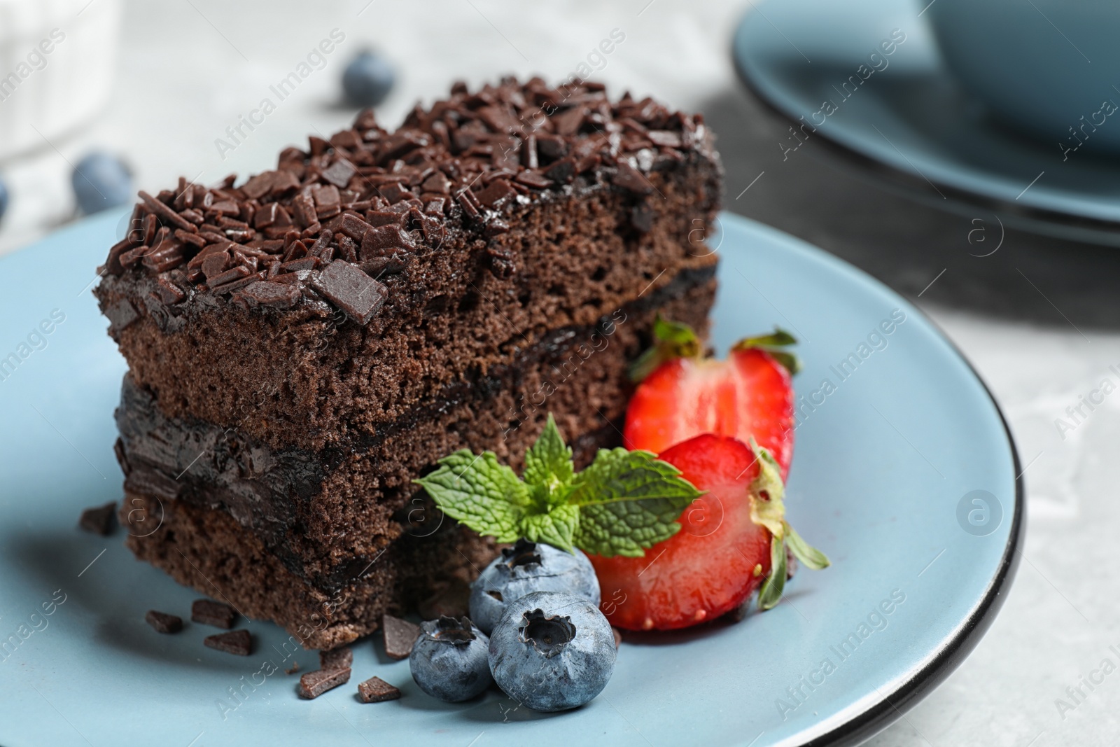 Photo of Delicious fresh chocolate cake with berries on table, closeup