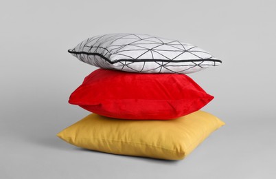 Photo of Stack of stylish soft pillows on grey background