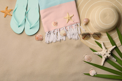 Flat lay composition with beach objects on sand. Space for text