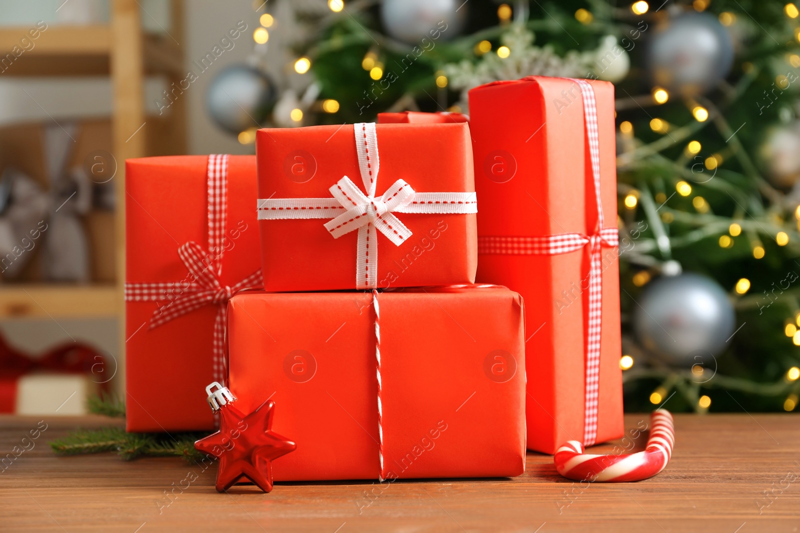 Photo of Beautiful gift boxes and blurred Christmas tree on background