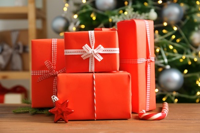 Photo of Beautiful gift boxes and blurred Christmas tree on background